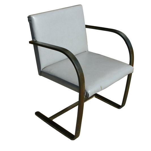 Gray vinyl Brno Chair, known for its minimalist design, comfortable seat, and durable construction.